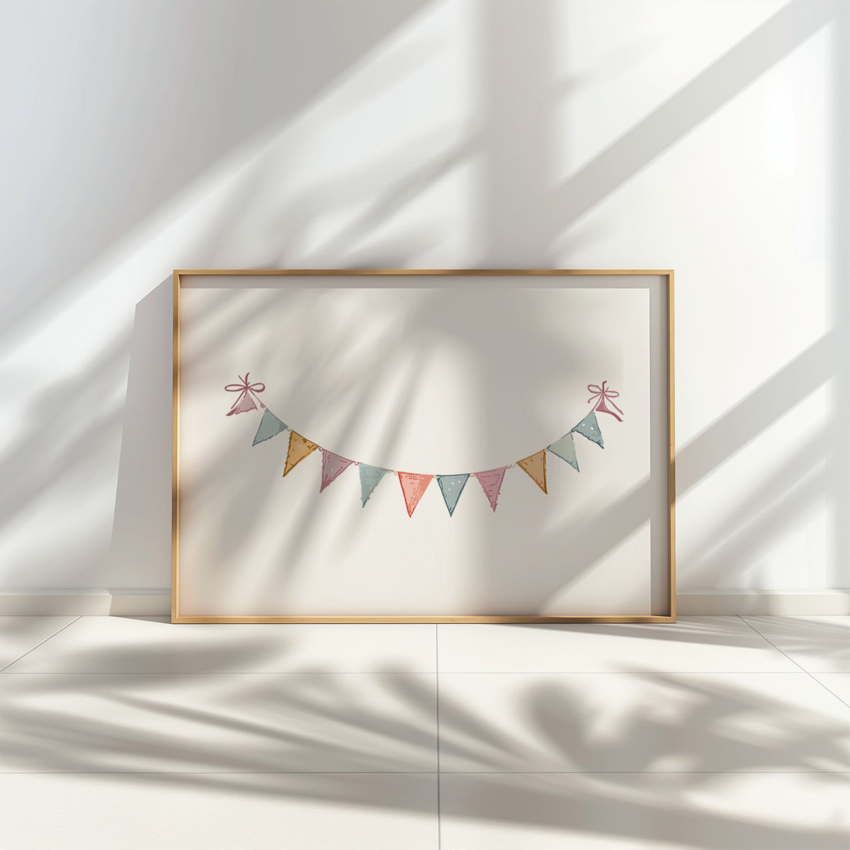 Pastel triangle bunting garland with bows nursery print in a thin oak frame leaning on a tiled floor in dappled sunlight