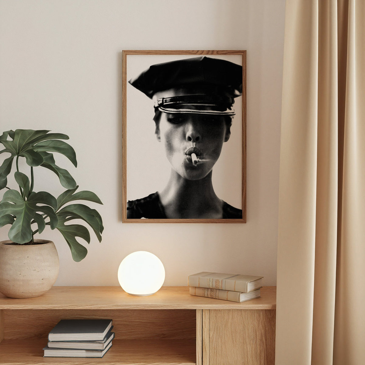 Close portrait under glossy leather cap print in a walnut frame above an oak cabinet with a glowing globe lamp