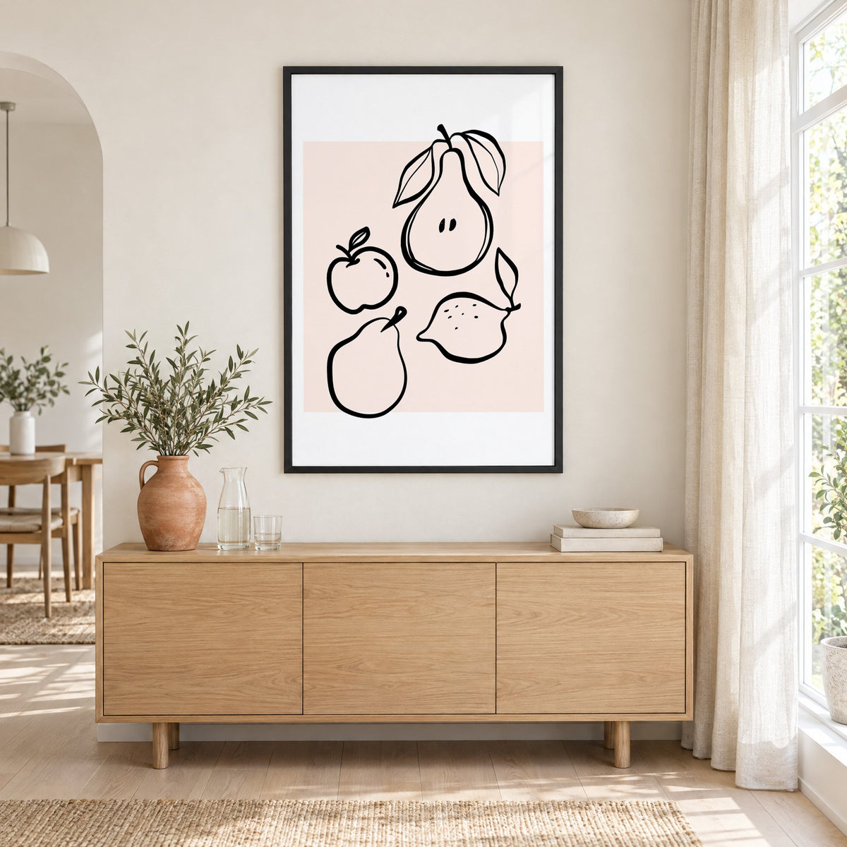 Pear apple lemon black line art print in a black frame above an oak sideboard with a terracotta vase of olive branches