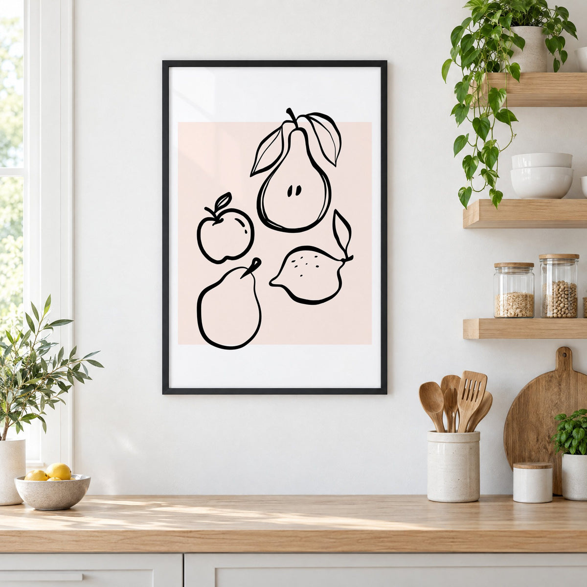 Pear apple lemon black line art print in a black frame in a white kitchen beside open wood shelves and glass jars