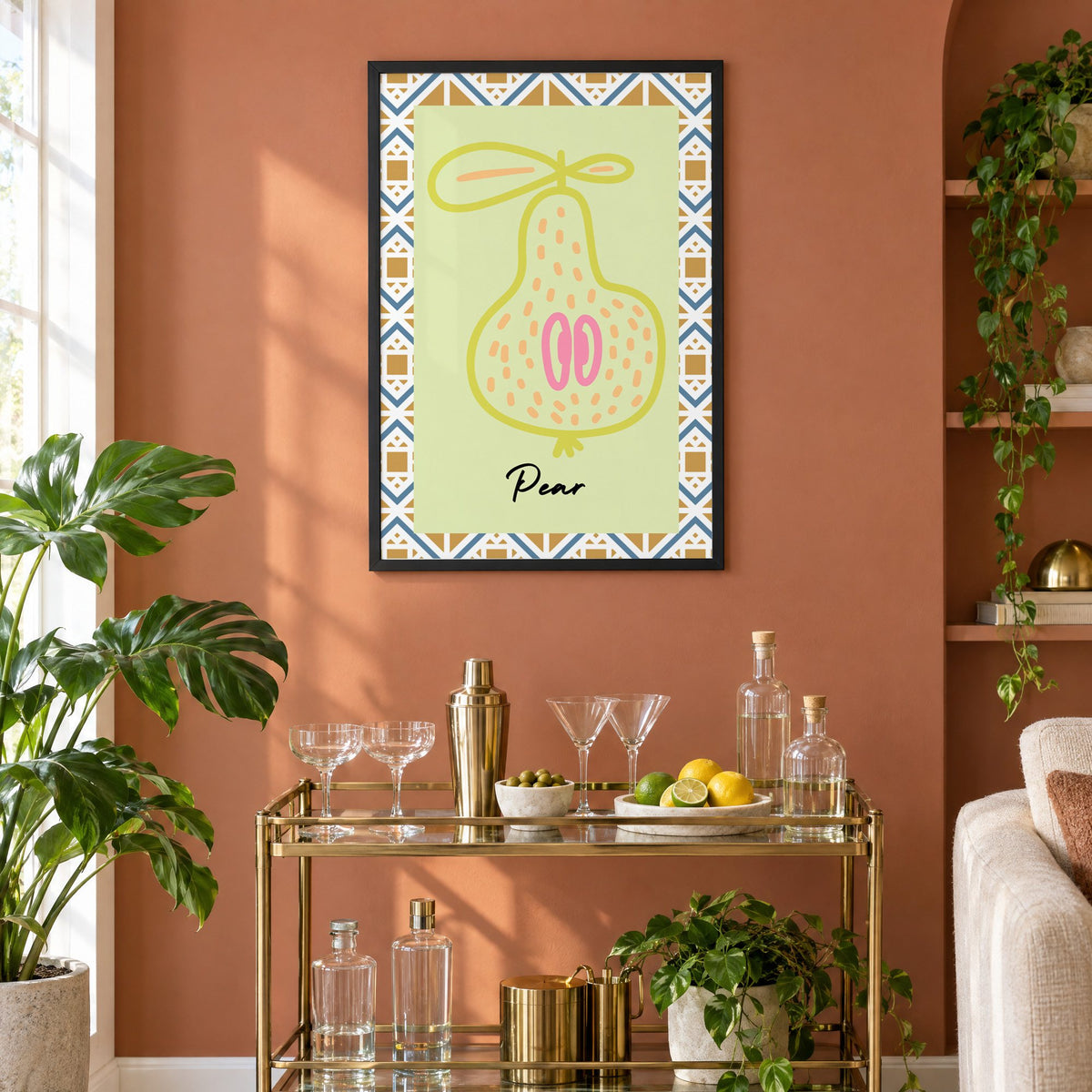 Pear lime line-art zigzag border print in a black frame on a terracotta wall above a brass bar cart with coupes and citrus