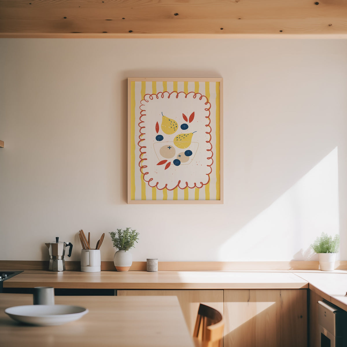 Pears and blueberries print in an oak frame above a wood counter with a moka pot