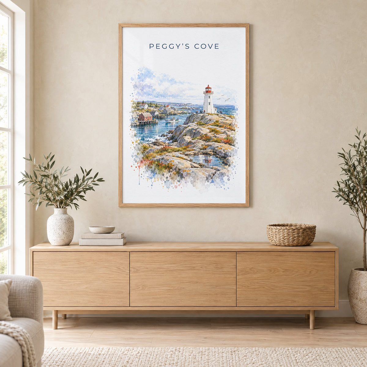 Peggy's Cove watercolor print in an oak frame above a light wood sideboard in a Scandinavian living room