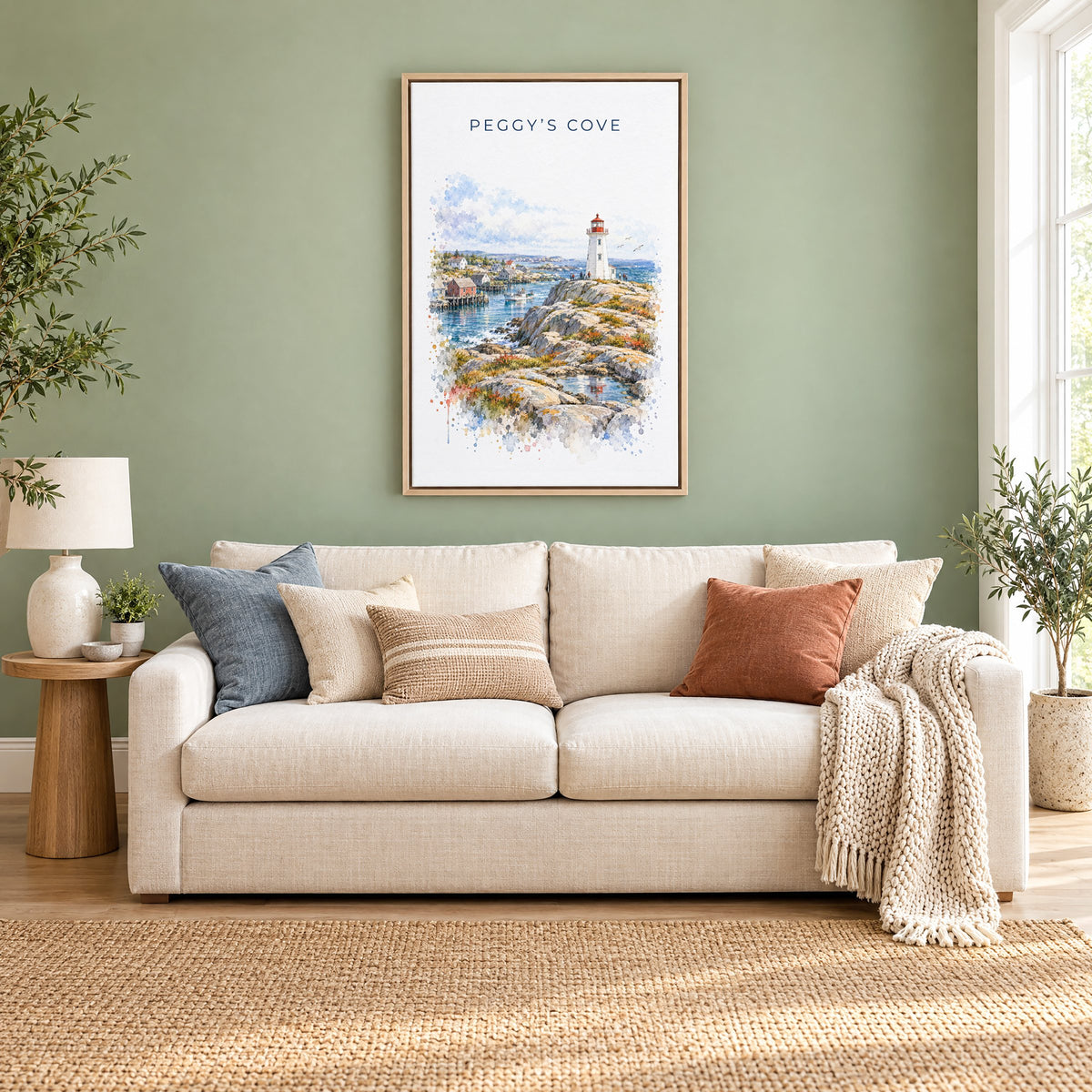 Peggy's Cove watercolor print as a natural floater canvas above a cream linen sofa on a sage green wall