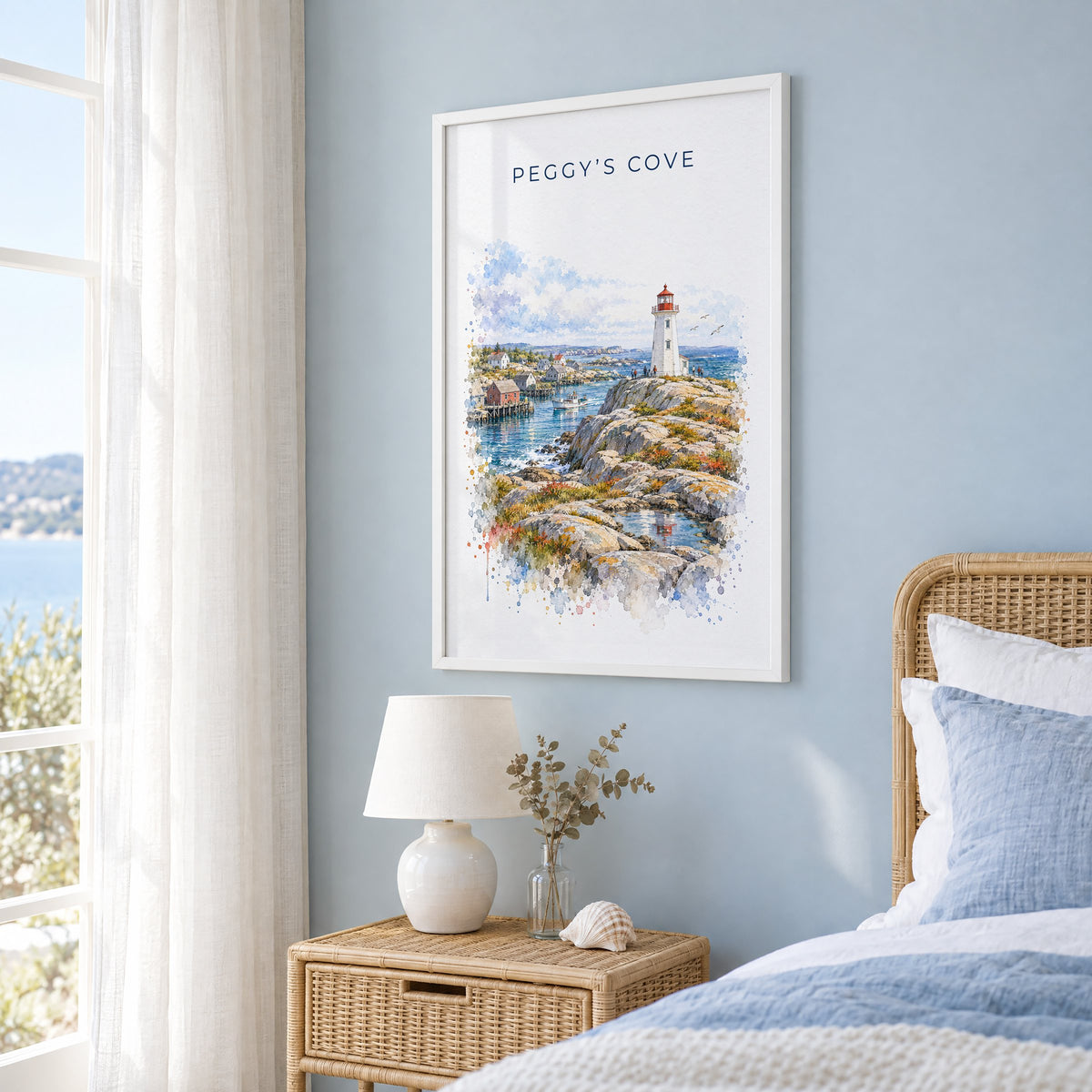 Peggy's Cove watercolor print in a white frame on a pale blue wall beside a rattan bed in a coastal bedroom