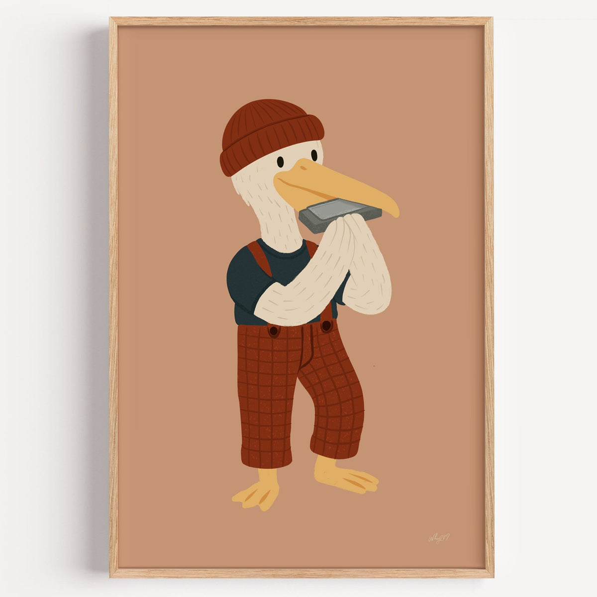 Pelican with harmonica and beanie nursery print in a light oak frame on a plain white wall