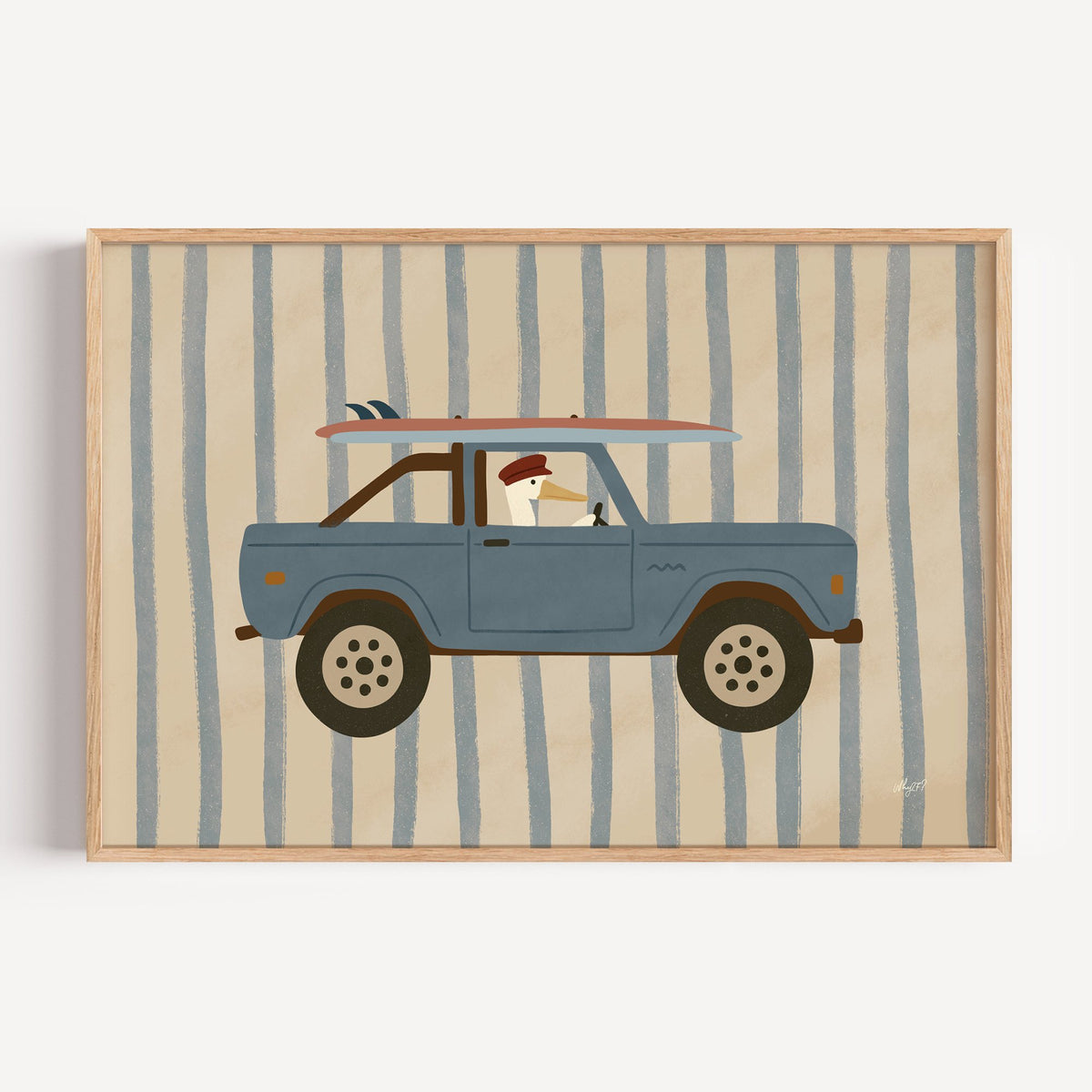 Pelican driving blue surf truck nursery print in a light oak frame on a plain white wall
