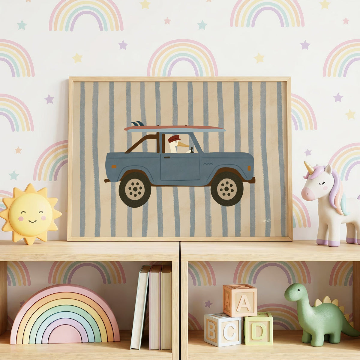 Pelican driving blue surf truck nursery print in an oak frame on a toy shelf against rainbow wallpaper