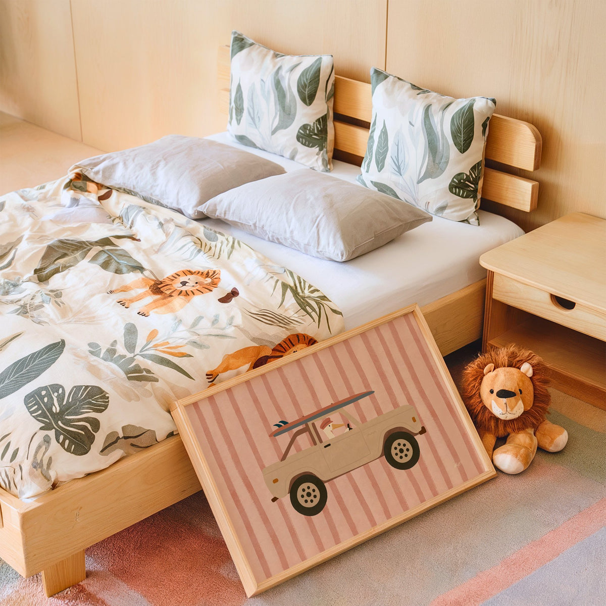 Pelican driving beige truck pink nursery print in an oak frame leaning on a kids bed by a lion plush