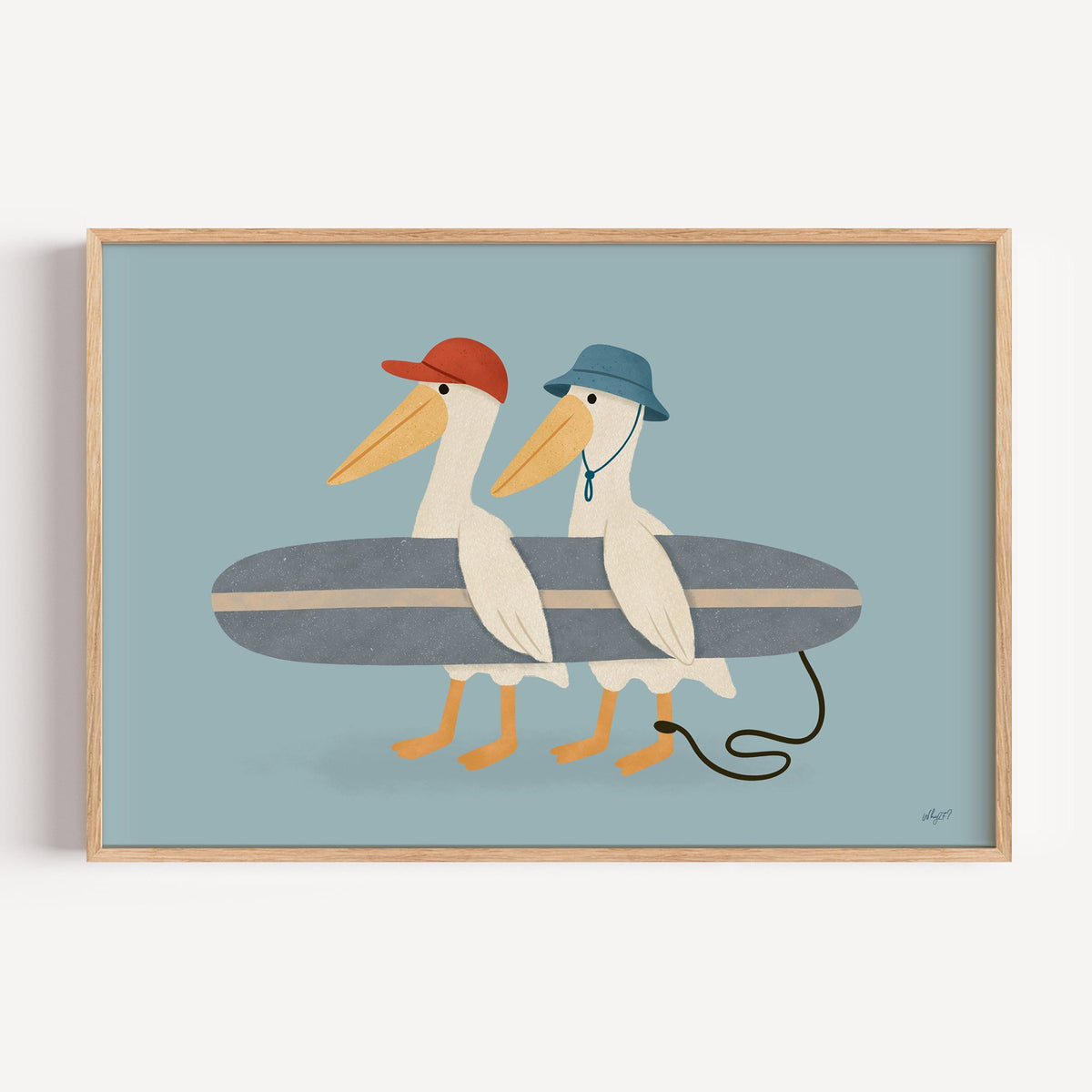 Two pelicans carrying surfboard nursery print in a light oak frame on a plain white wall