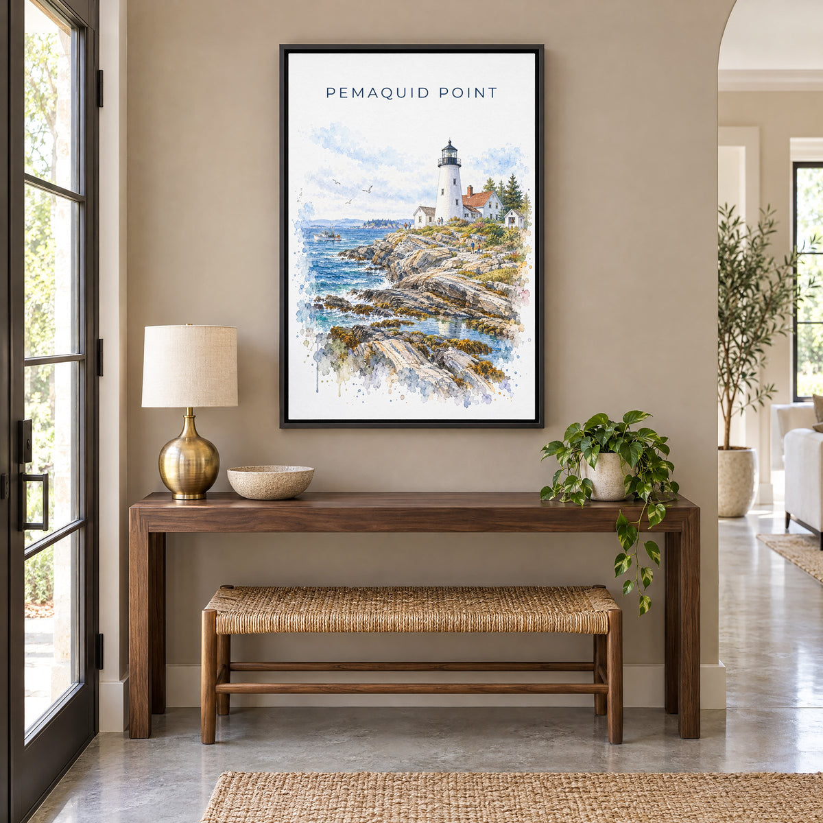 Pemaquid Point watercolor print as a black floater canvas above a walnut console and woven bench in an entryway