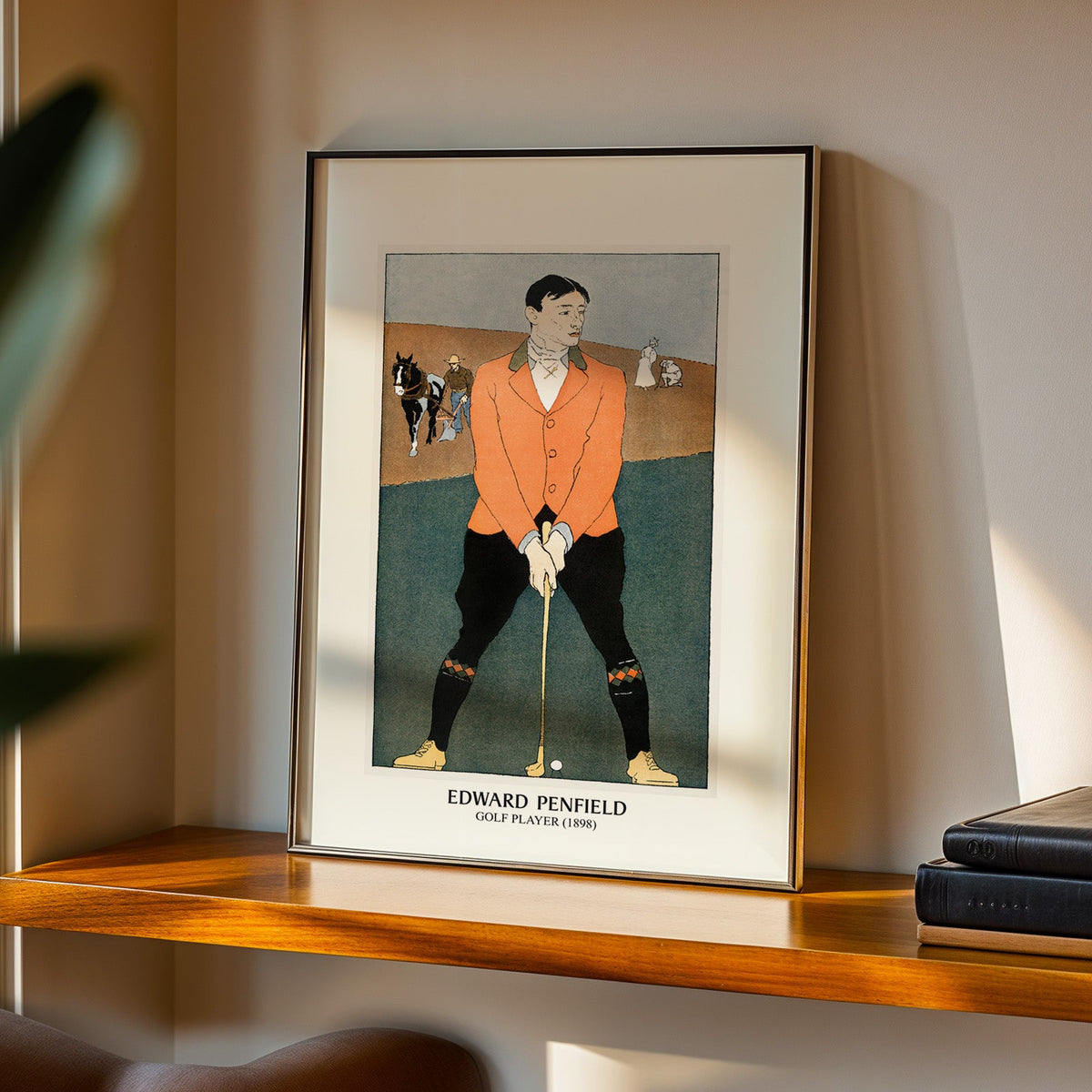 Golf Player print in a black frame on a walnut shelf in warm evening light