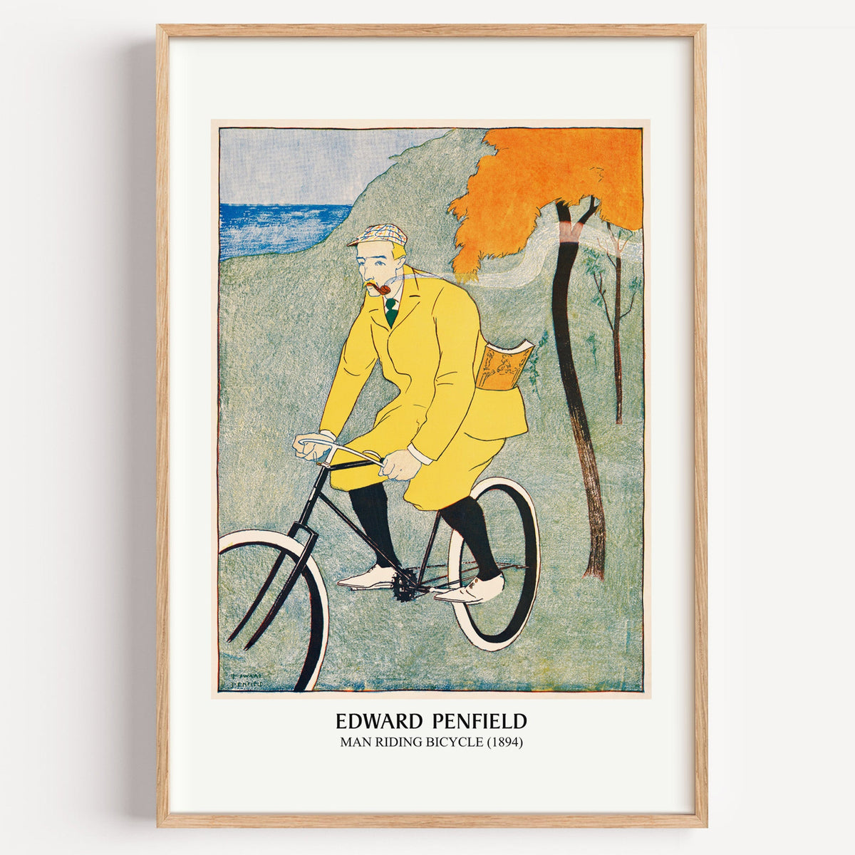 Edward Penfield Man Riding Bicycle print in a light oak frame on a white wall