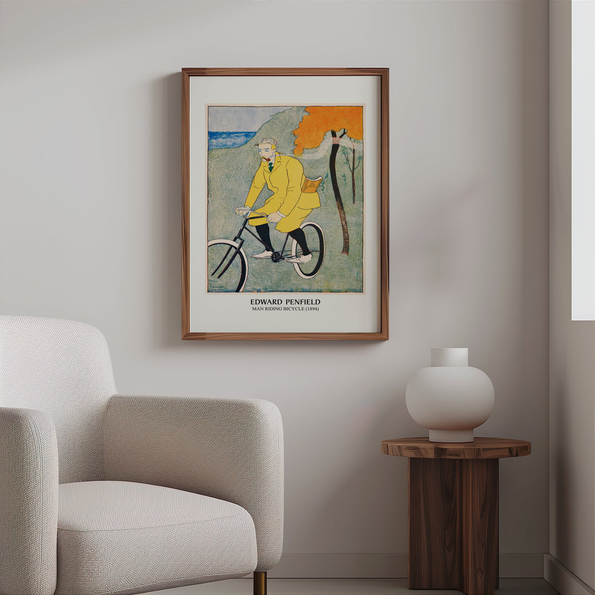 Vintage cycling poster in a slim walnut frame above a bouclé armchair