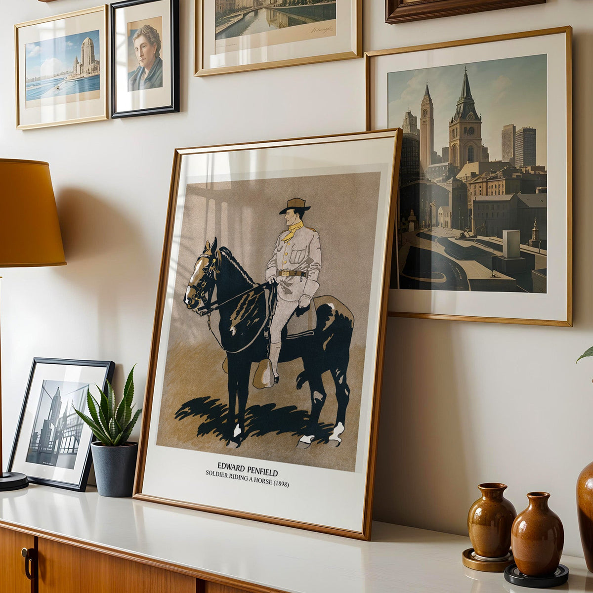 Penfield horse print shown in a gold frame leaning on a sideboard in a gallery wall