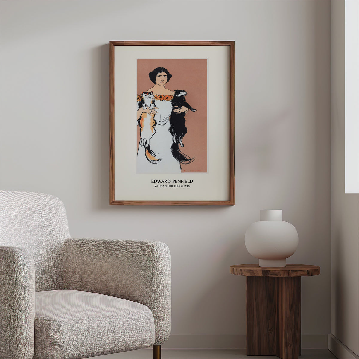 Vintage cat poster in a slim walnut frame above a bouclé armchair