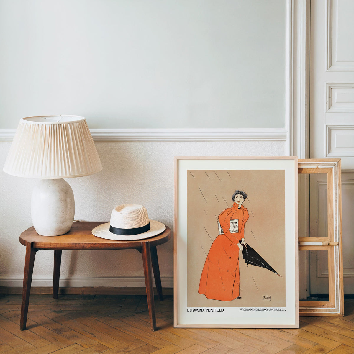 Penfield rainy day poster in a light wood frame leaning by a bench and hat