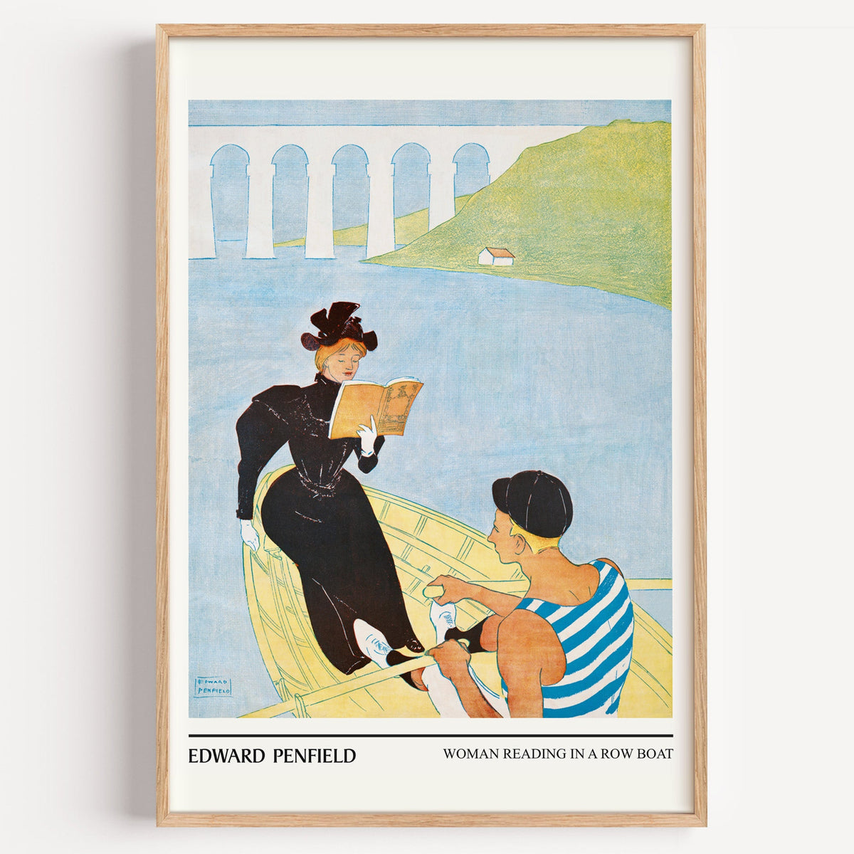 Penfield Woman Reading in a Row Boat print in a light oak frame on a white wall