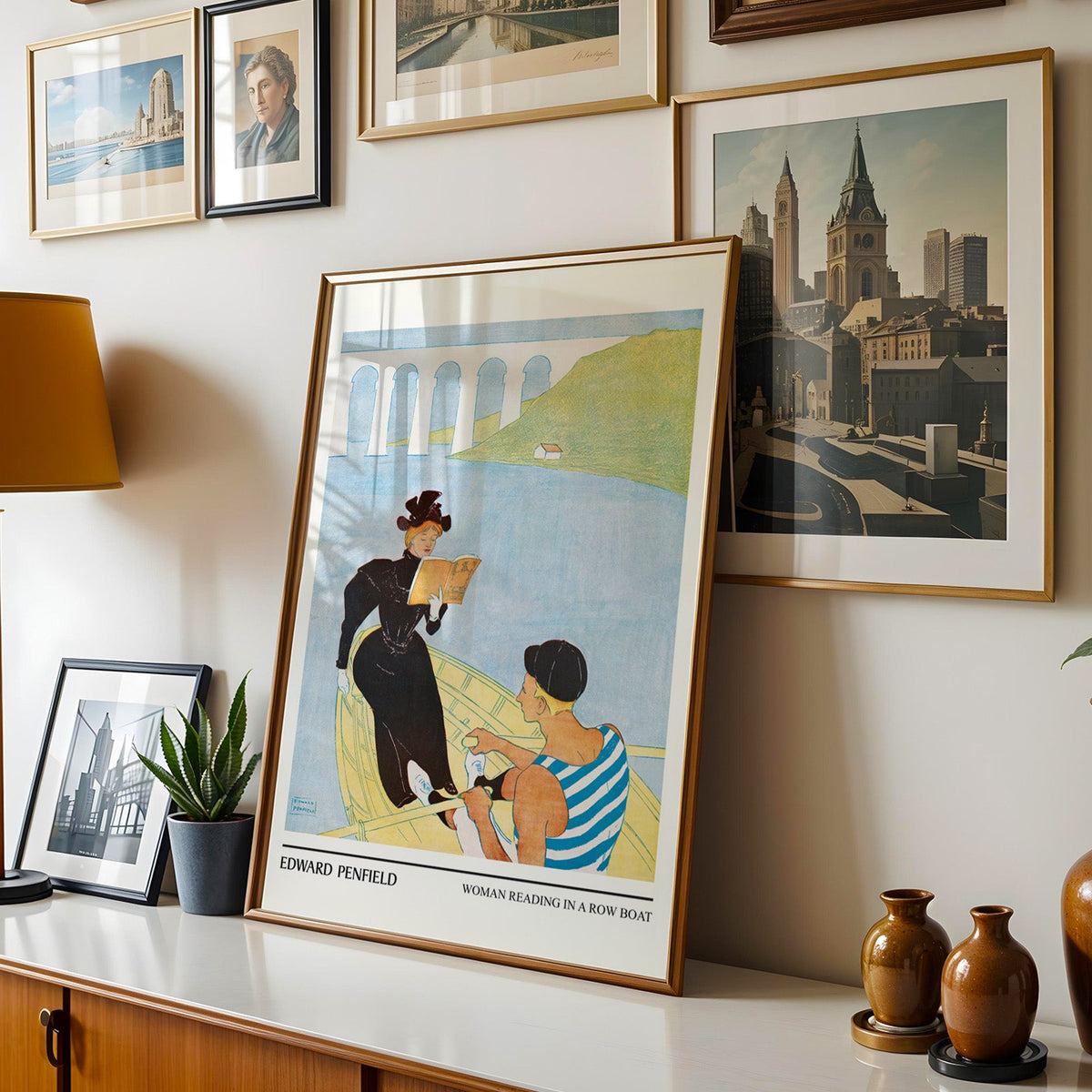Penfield boating poster shown in a gold frame leaning on a sideboard