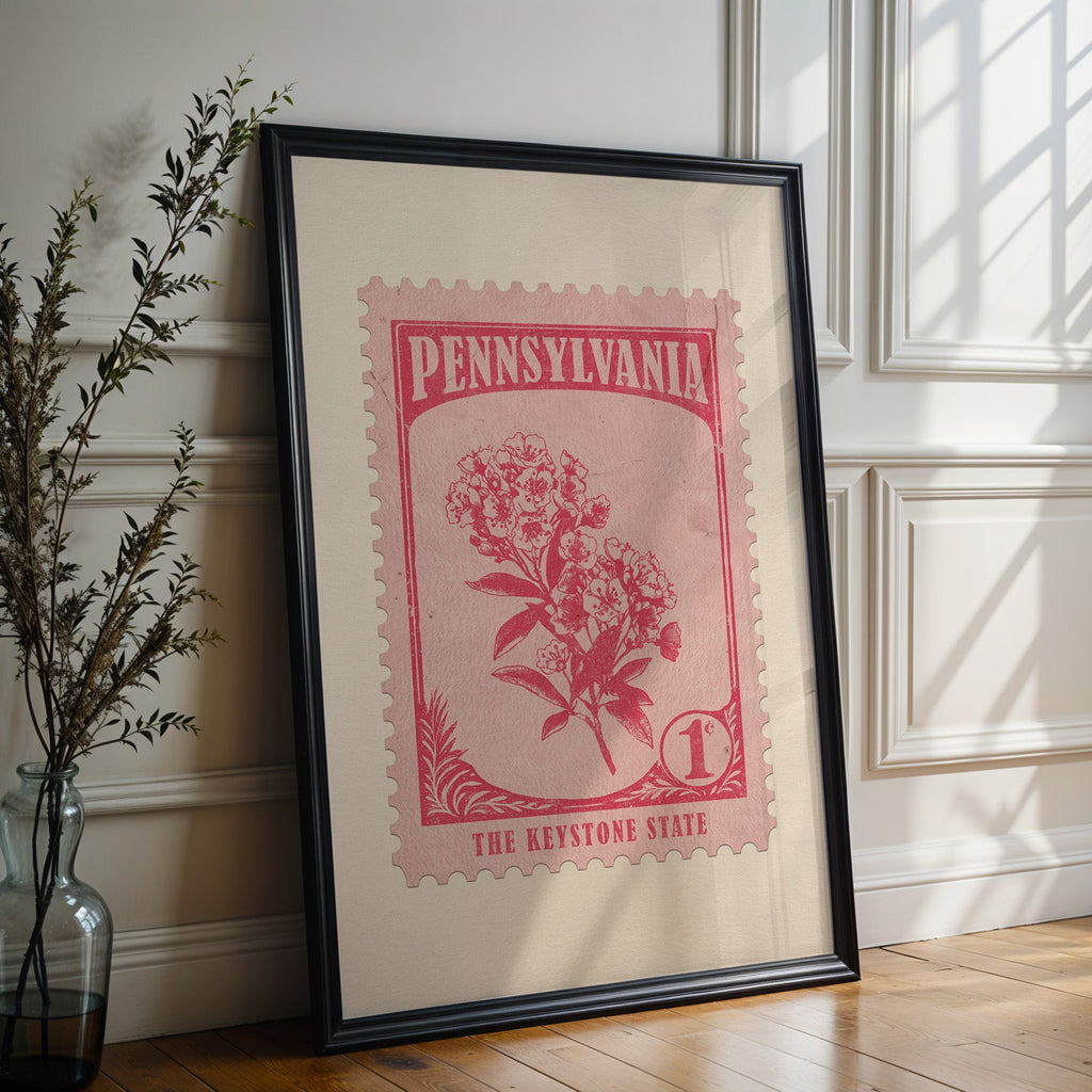 Pennsylvania state flower print in a black frame leaning against a white panelled wall beside olive branches