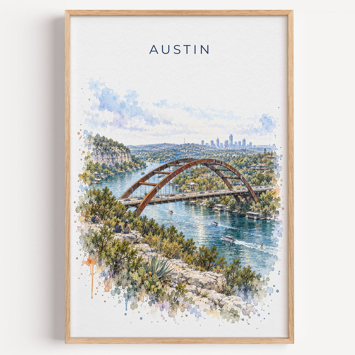 Pennybacker Bridge Austin watercolor print in a light oak frame on a plain white wall