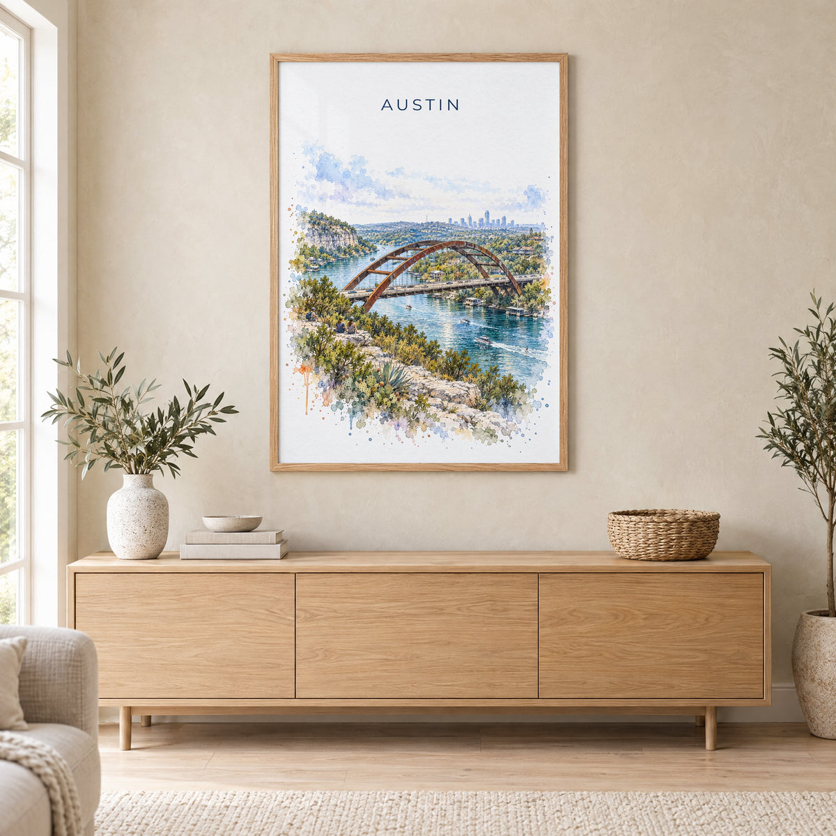 Pennybacker Bridge Austin watercolor print in an oak frame above a light wood sideboard in a Scandinavian living room