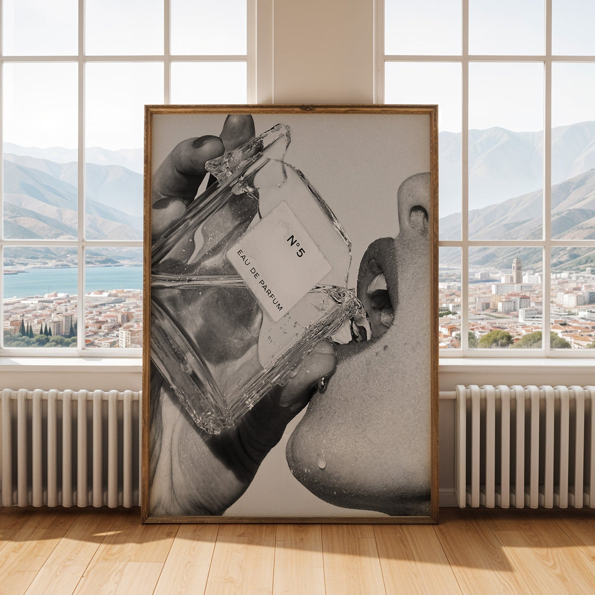 Cut-glass perfume bottle at a woman's lips print shown in an antique gold frame by tall windows with a sea view