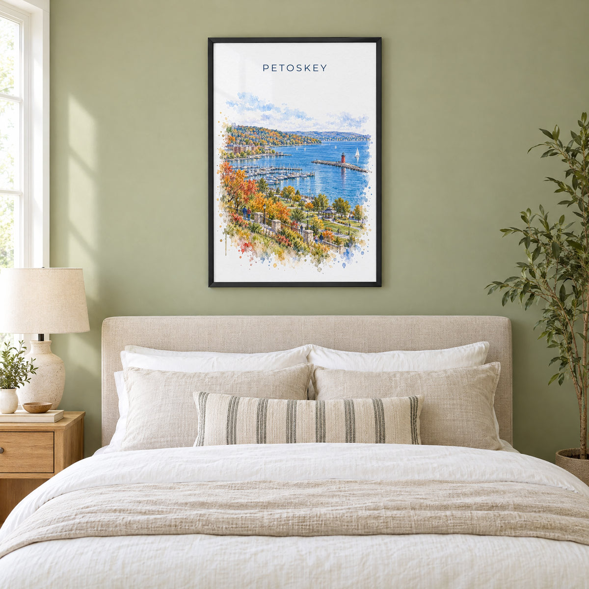 Petoskey watercolor print in a black frame above an upholstered headboard in a sage green bedroom