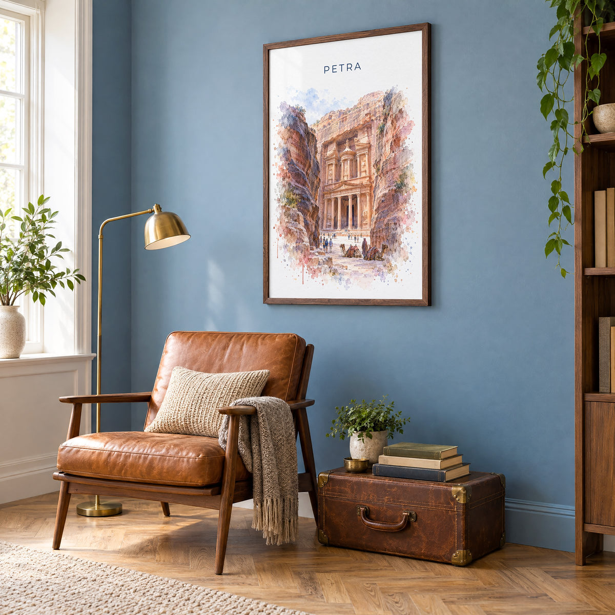 Petra watercolor print in a walnut frame on a blue wall above a leather armchair in a reading nook