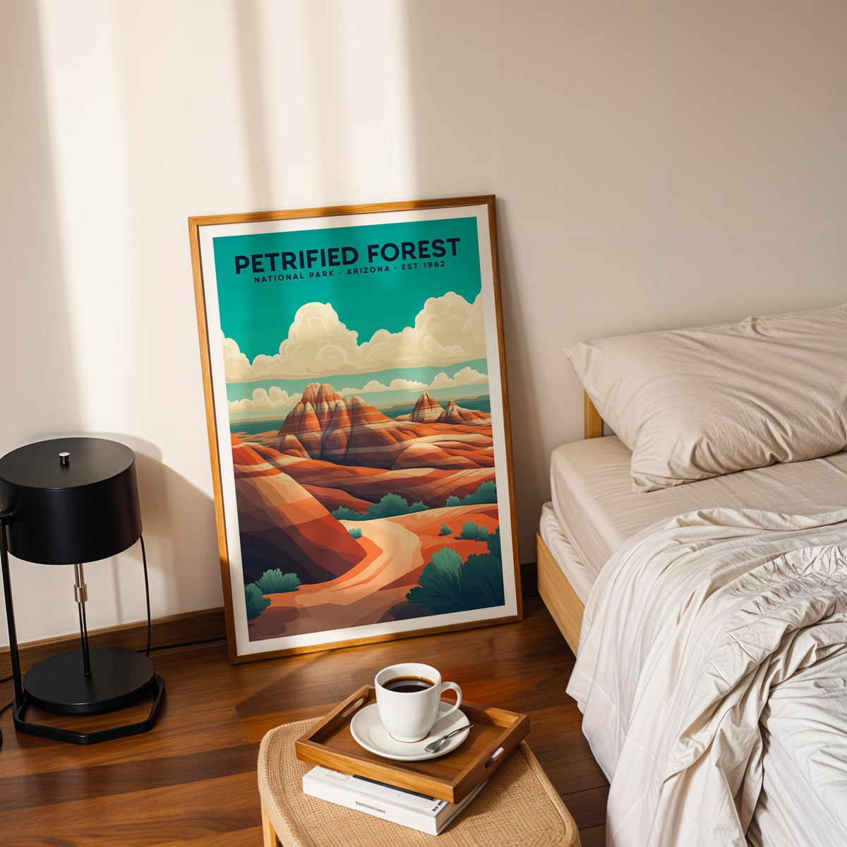 Petrified Forest National Park print in an oak frame leaning on a bedroom floor beside the bed and a coffee tray