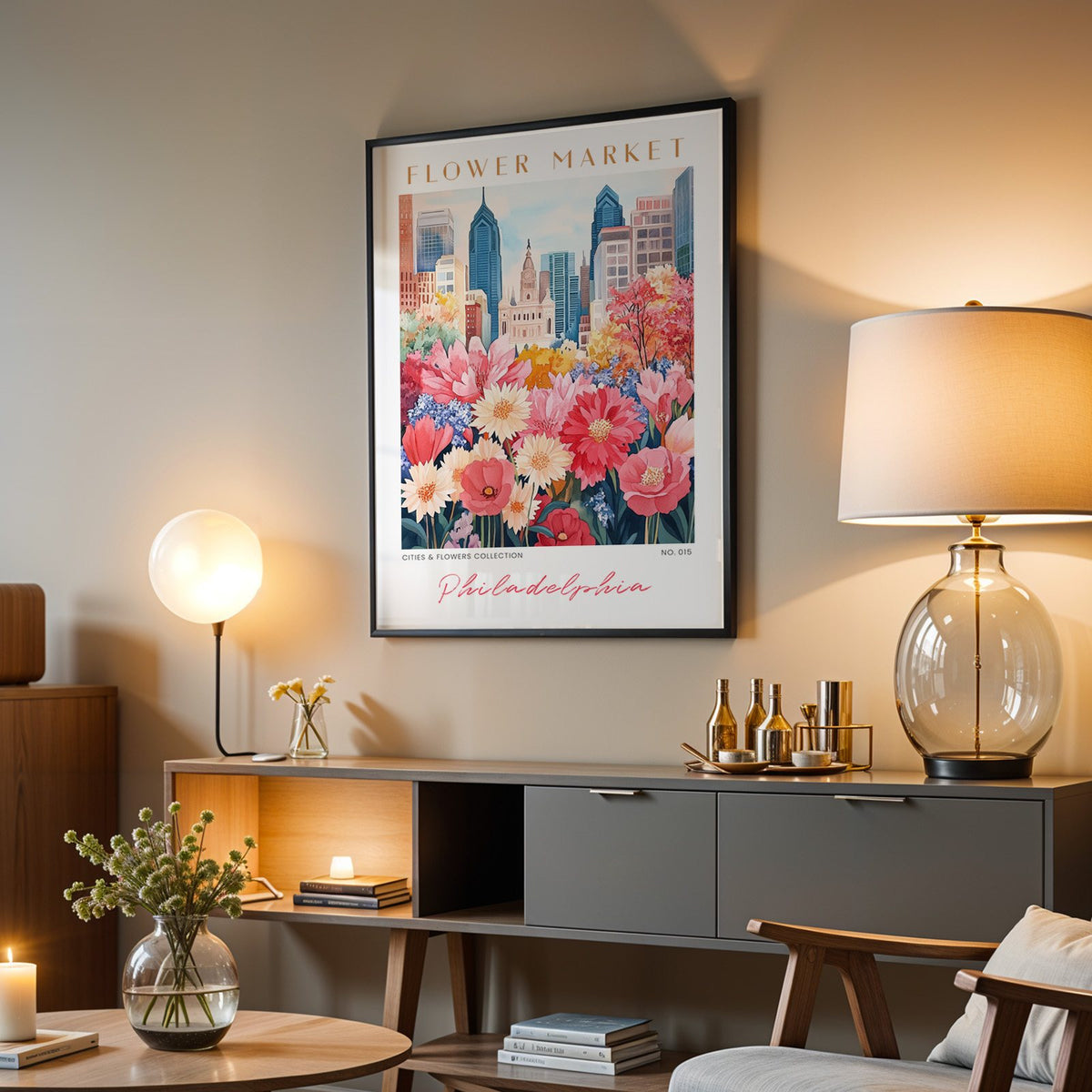 Philadelphia flower market print in a black frame above a grey media console with a glass table lamp