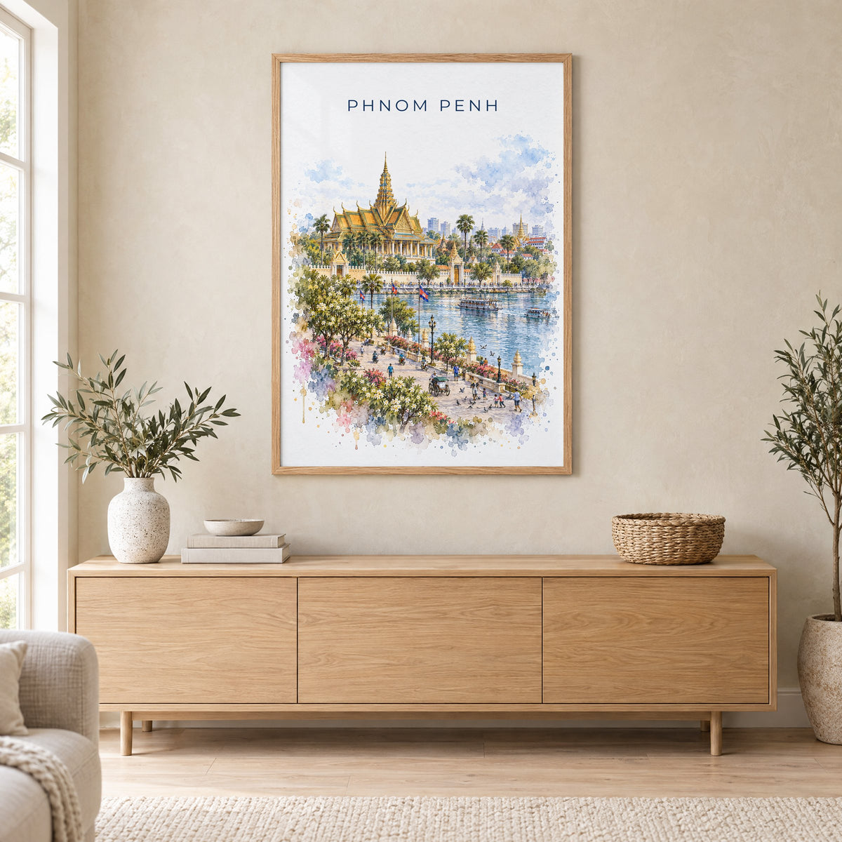 Phnom Penh watercolor print in an oak frame above a light wood sideboard in a Scandinavian living room