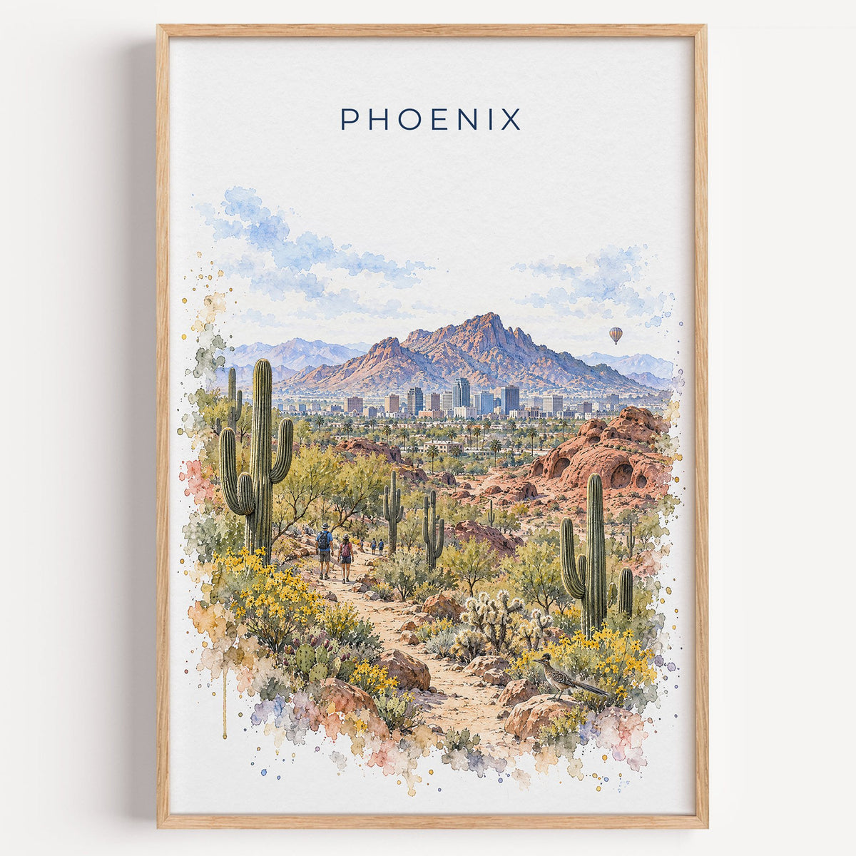 Phoenix watercolor print in a light oak frame on a plain white wall