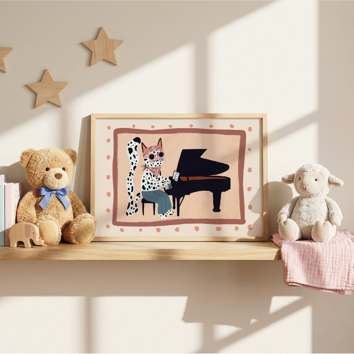 Spotted cat playing grand piano nursery print in an oak frame on a wall shelf between a teddy bear and a toy lamb