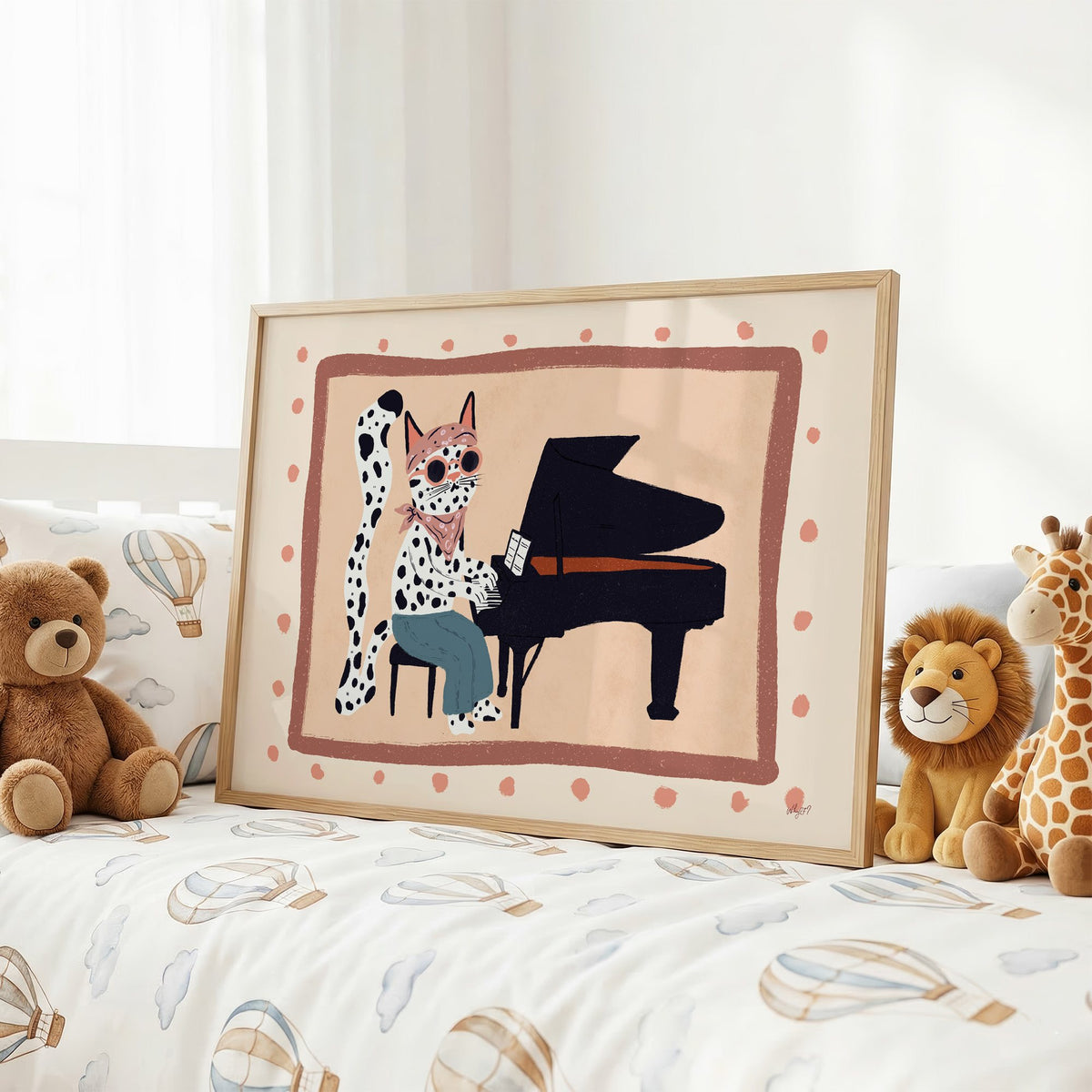 Spotted cat playing grand piano nursery print in an oak frame on a kids bed with hot air balloon bedding