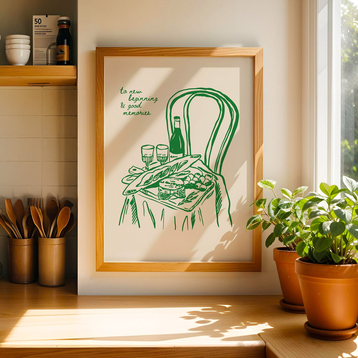 Picnic basket print in a light pine frame beside a ceramic jar of wooden spoons