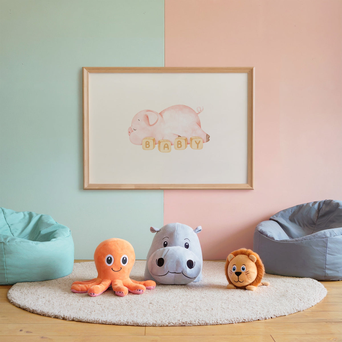Sleeping pink piglet behind BABY blocks nursery print in an oak frame on a mint and pink wall above plush toys
