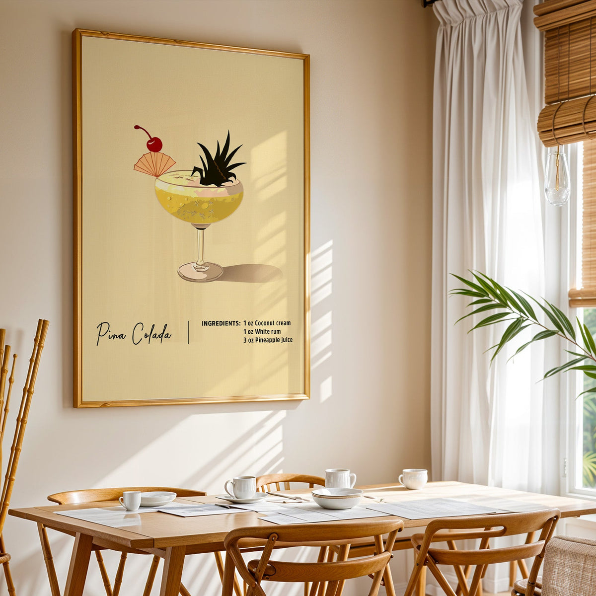 Pina colada recipe print shown in a gold frame above a breakfast table by a curtained window