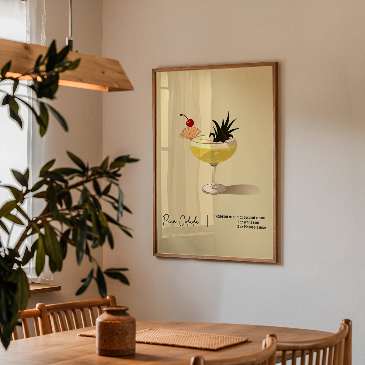 Pina colada recipe print in a walnut frame above a dining table with olive branches