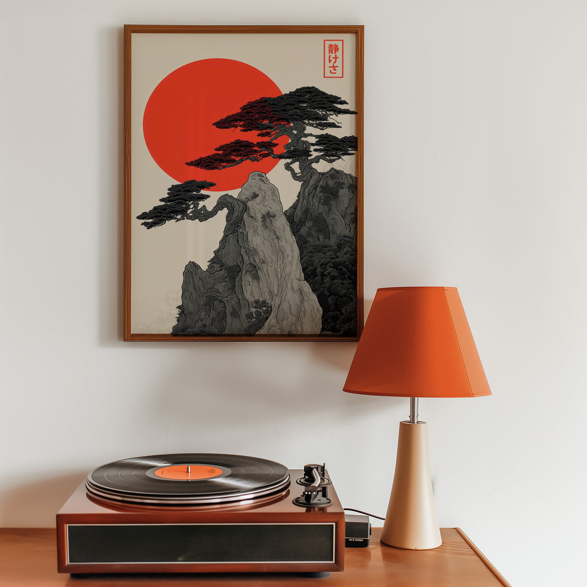 Ink pine cliff with red sun print in a walnut frame above a sideboard with a record player