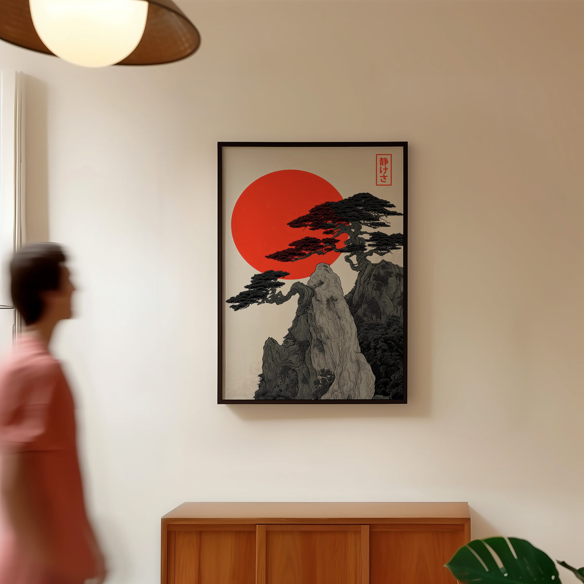 Ink pine cliff with red sun print in a black frame in a hallway under a rattan pendant
