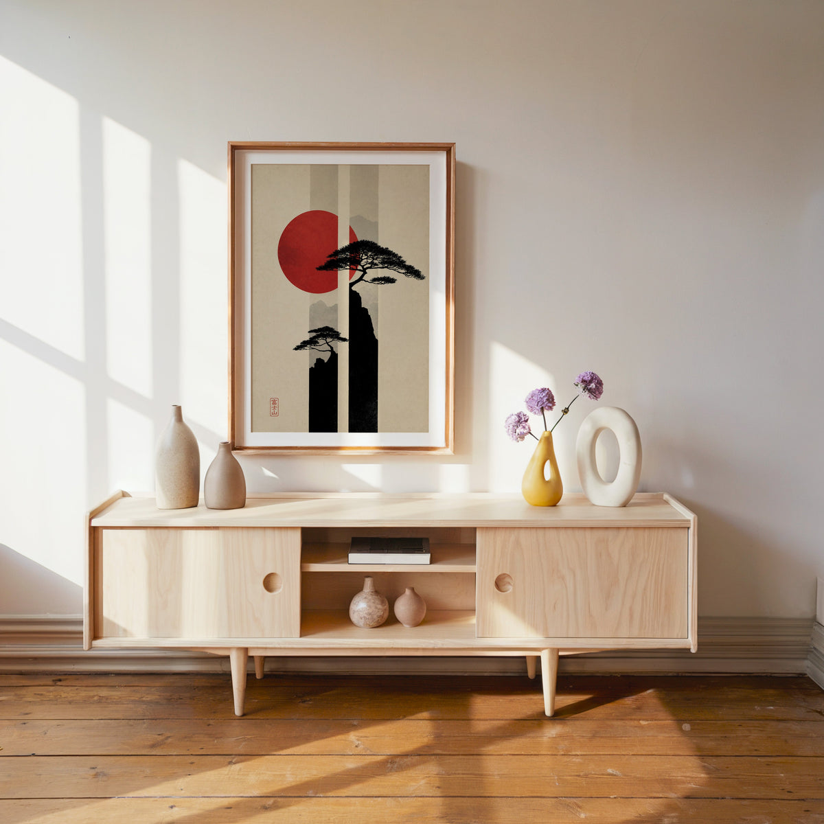 pine cliffs with red sun and stripes print shown in a wood frame with a white mat above a pale wood media console