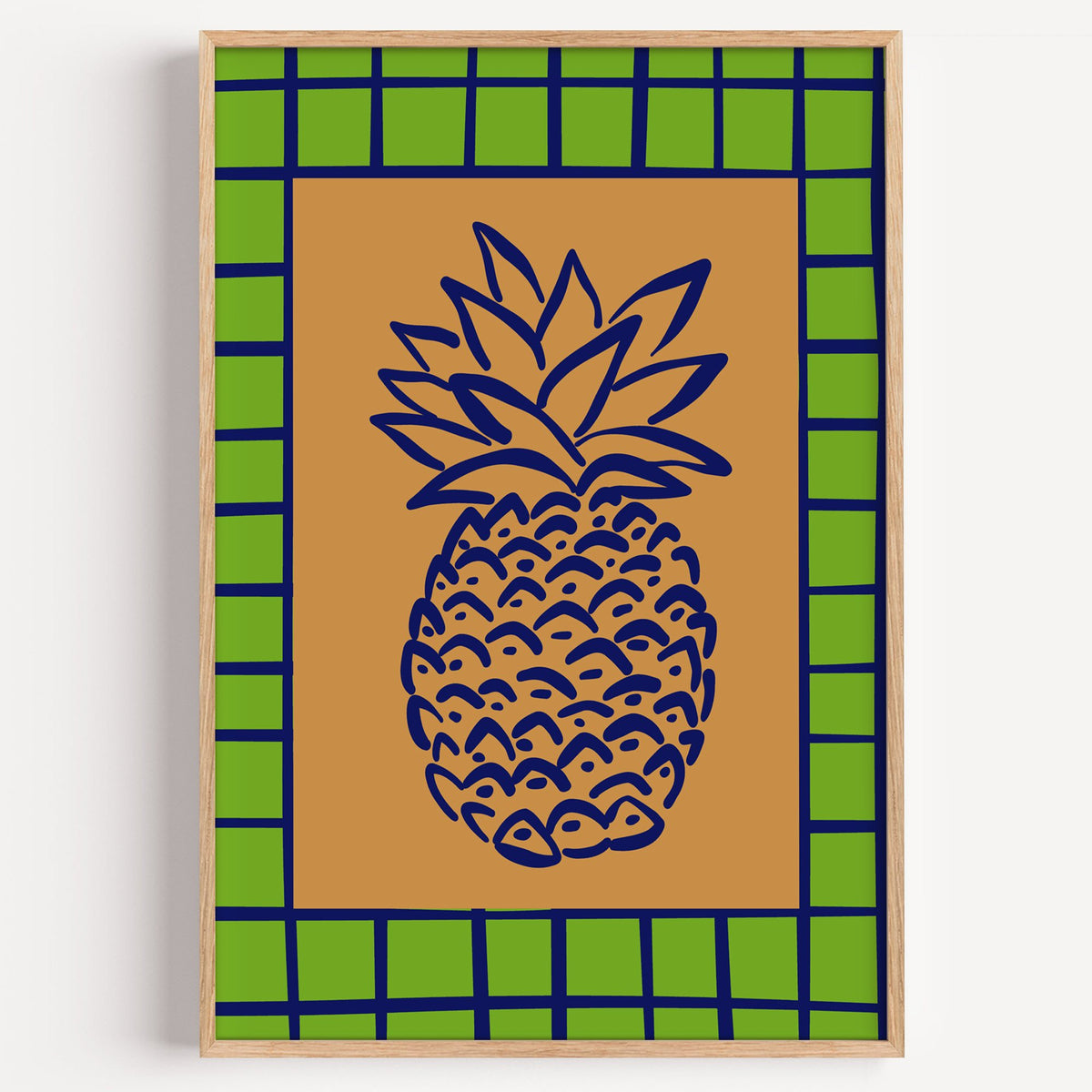Pineapple navy line on ochre with green grid print in a light oak frame on a plain white wall