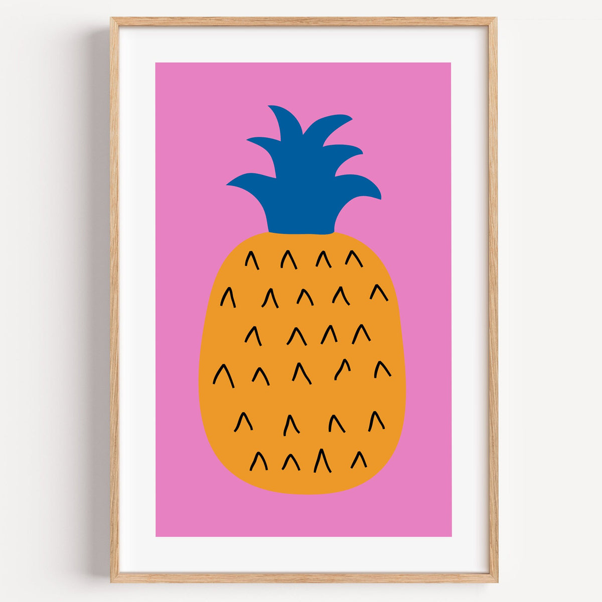 orange pineapple cobalt crown hot pink print in a light oak frame on a plain white wall