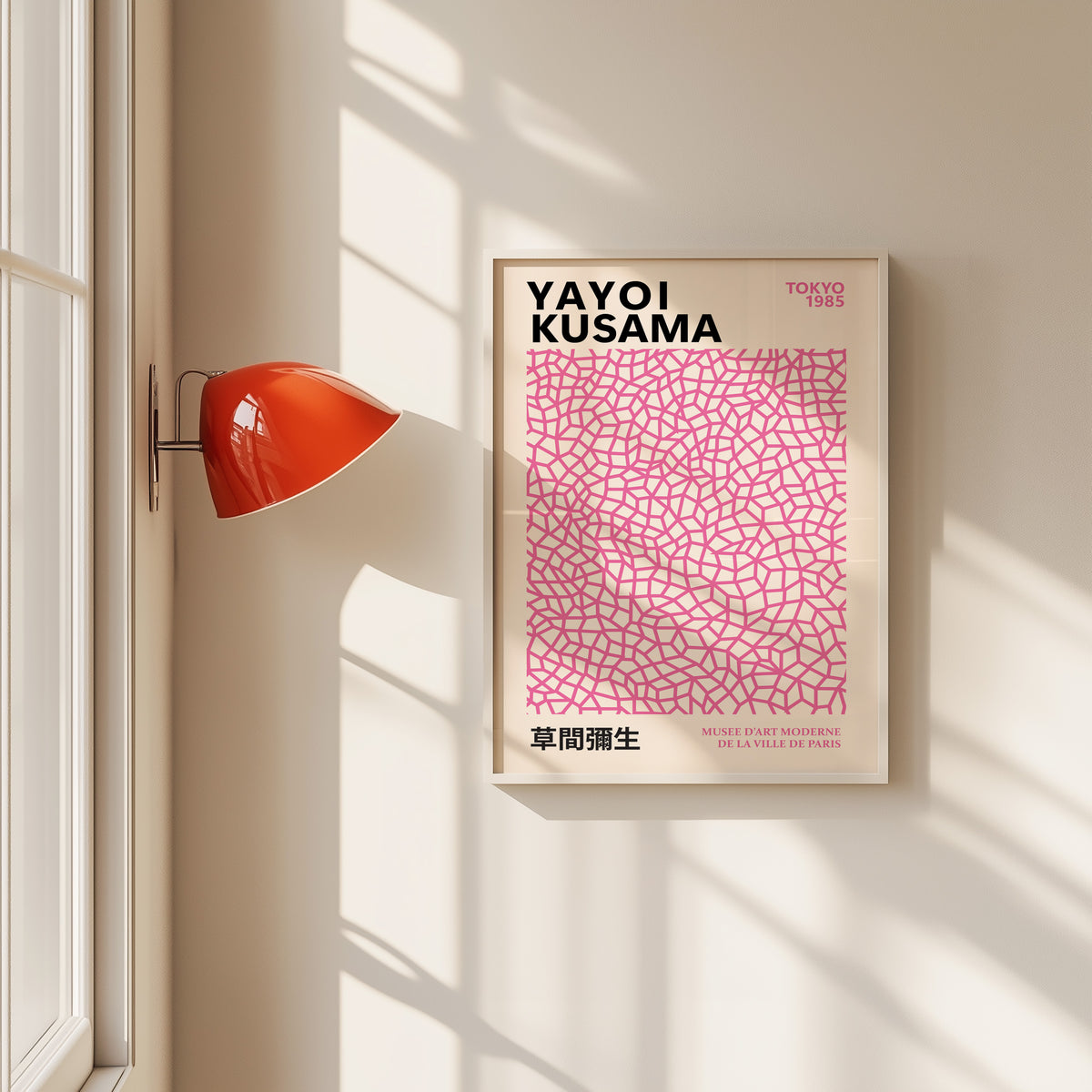 Yayoi Kusama inspired pink net pattern print in a white frame by a red wall lamp