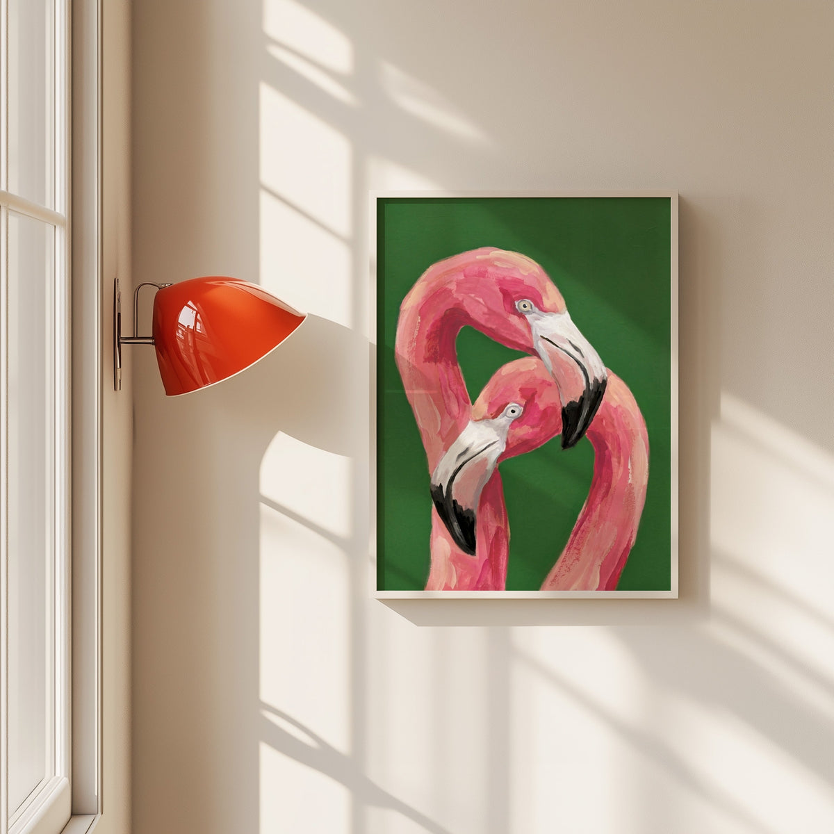 Pink flamingo pair print in a white frame beside a red wall sconce