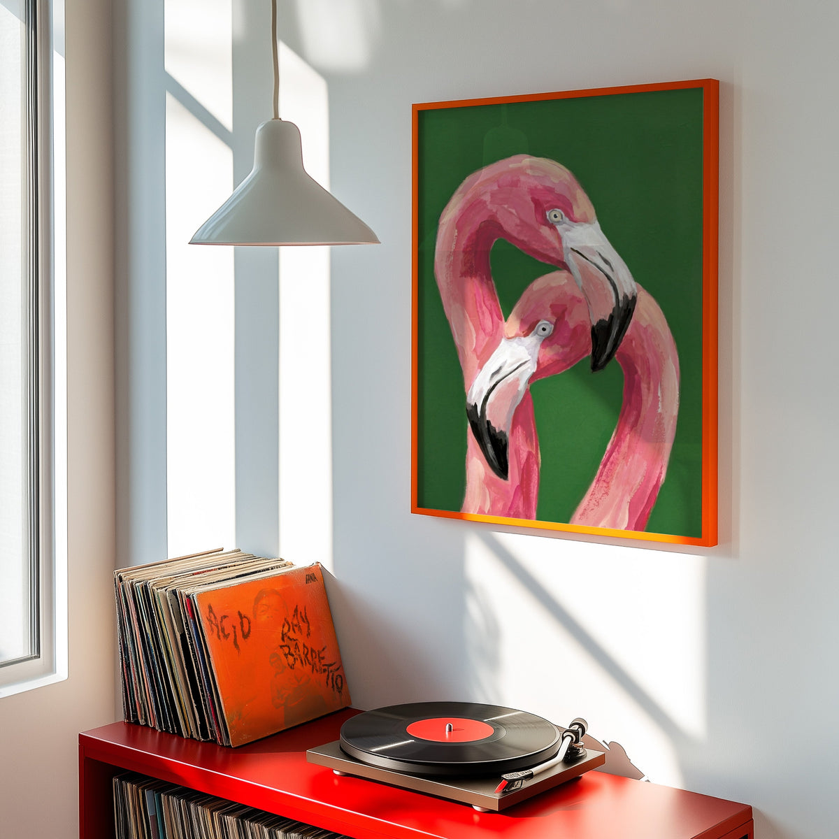 Flamingo wall art print shown in an orange frame above a red record cabinet and turntable