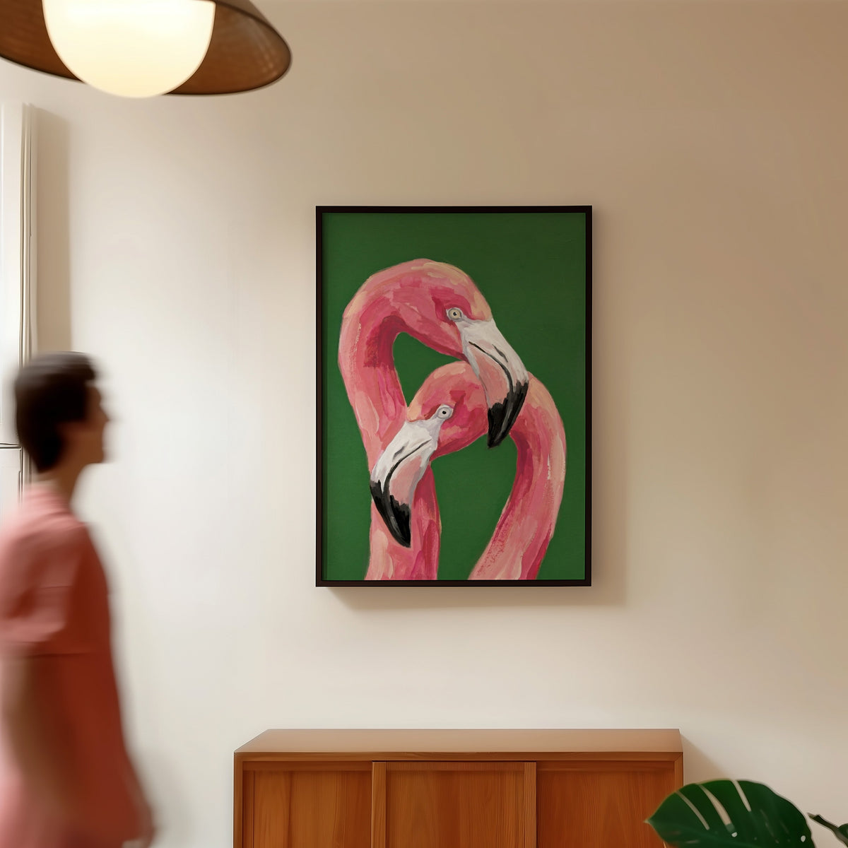 Tropical flamingo painting print in a black frame in a hallway under a rattan pendant