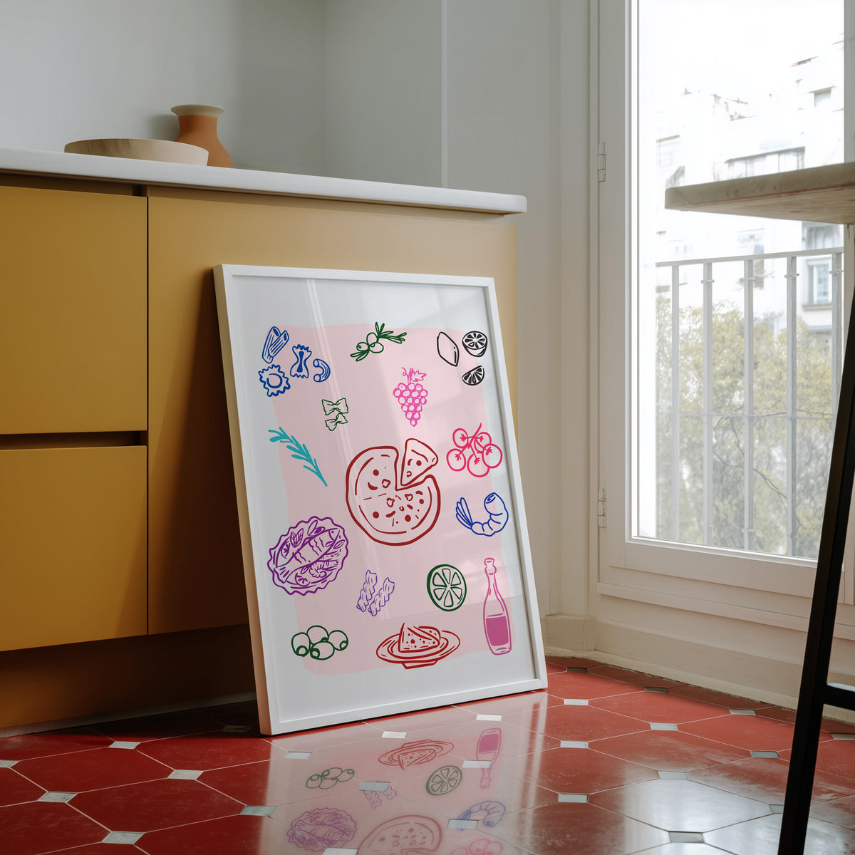 Food doodle print in a white frame against yellow cabinets on a red tiled floor