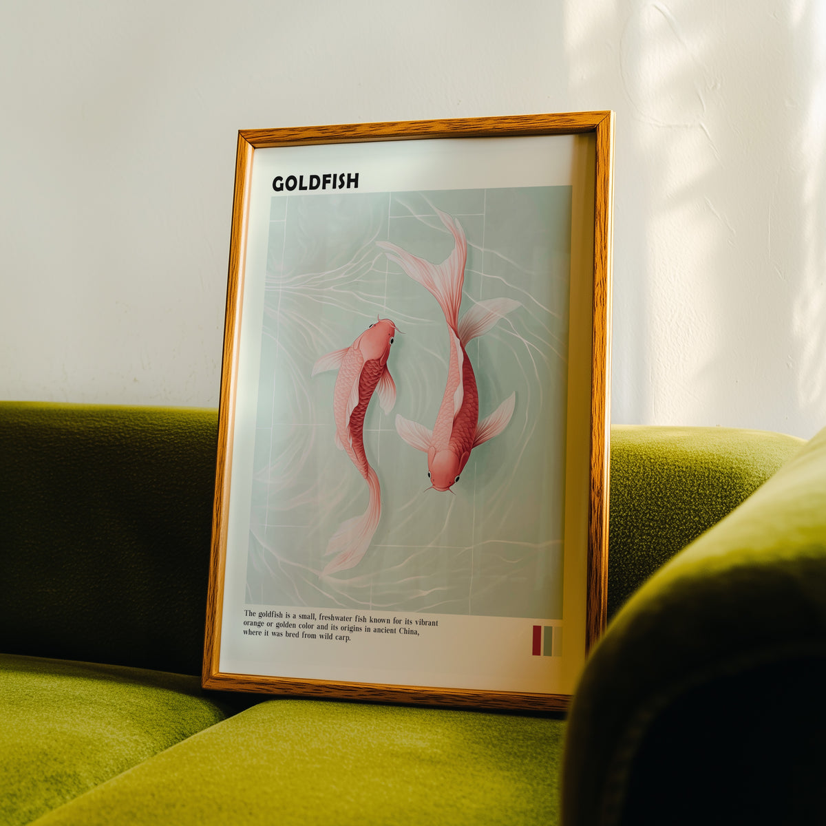Pink goldfish pair on mint water print in an oak frame propped on a green velvet sofa
